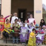 Niños/as, madres y profes disfrazados en la puerta del colegio